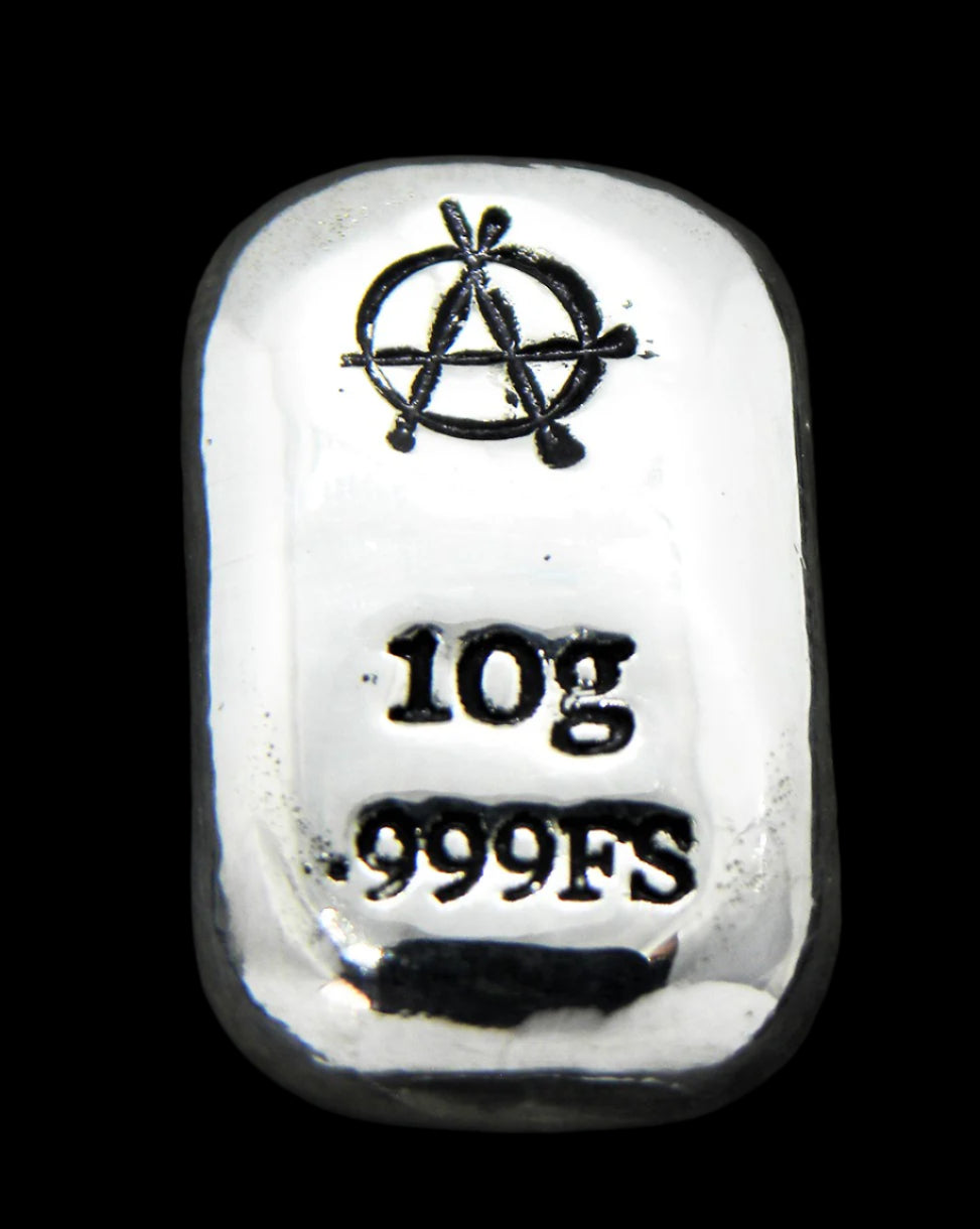 Close-up of a 10-gram 999 fine silver rectangular bar with a polished, reflective surface. The Anarchy symbol stamp is stamped on the top half of the bar and 10g 999FS on the bottom half. The bar is positioned vertically.