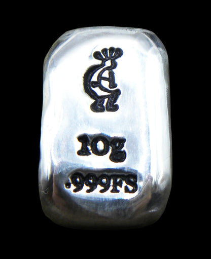 Close-up of a 10-gram 999 fine silver rectangular bar with a polished, reflective surface. The Kokopelli stamp is stamped on the top half of the bar and 10g 999FS on the bottom half. The bar is positioned vertically.
