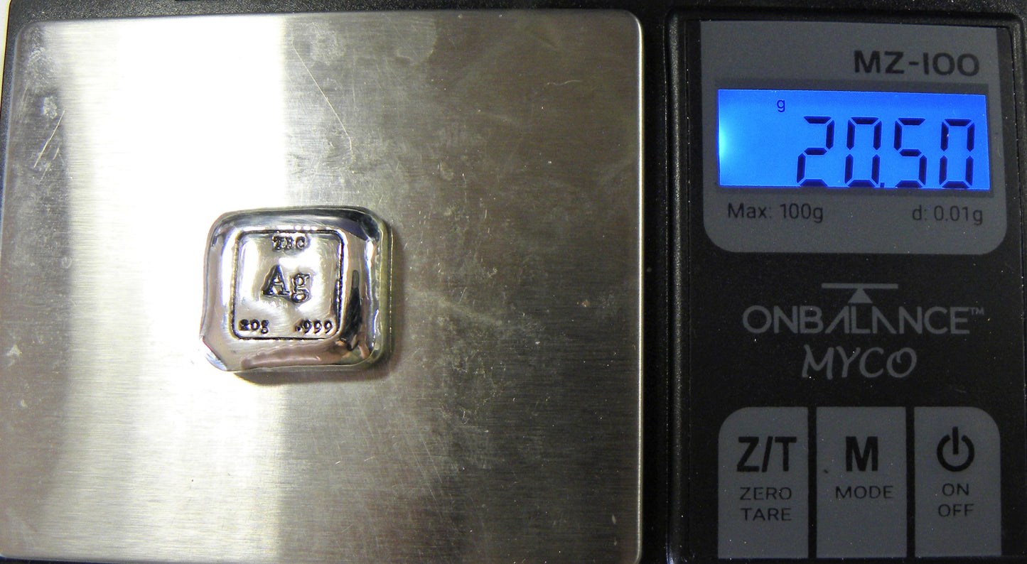 A 20g hand-poured fine silver bullion bar placed on digital scales, displaying an overweight reading. The front features bold TBC and 999 purity stamps with a deep black patina, enhancing contrast and detail. The high-polish surface reflects light, showcasing its handcrafted quality. A premium investment piece from the Tasmanian Bullion Company.